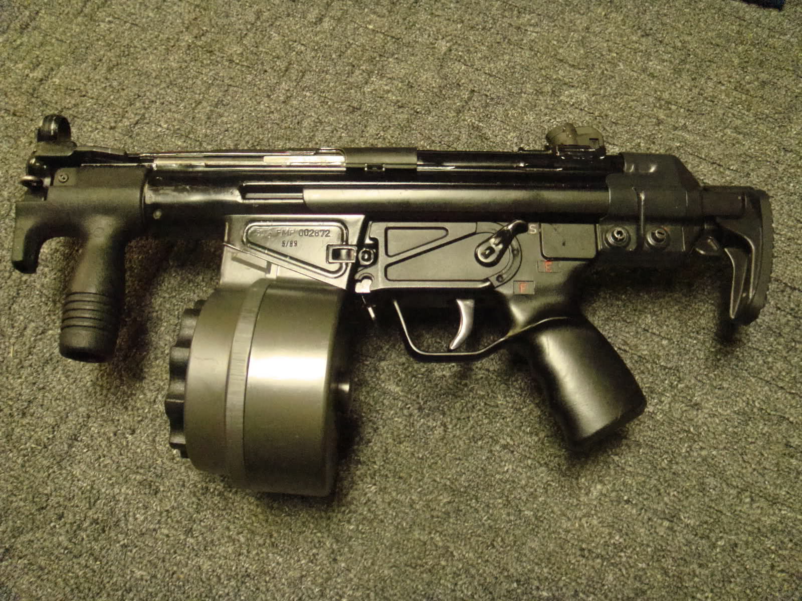 customized HK G3, with ultra-short barrel, MP5K foregrip, and drum magazine...
